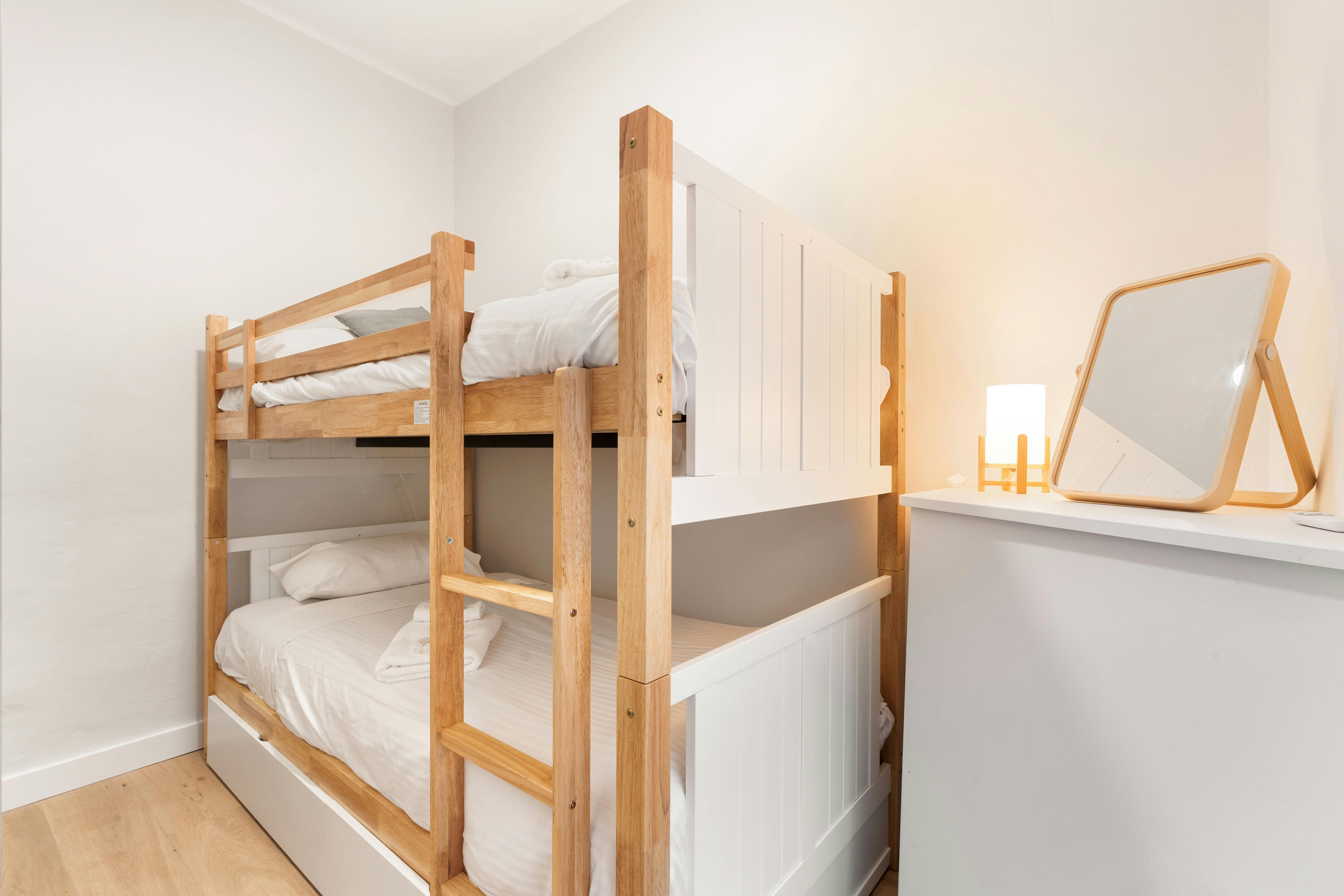 Bright and modern bedroom with a queen-sized bed, plant, and minimalistic decor.