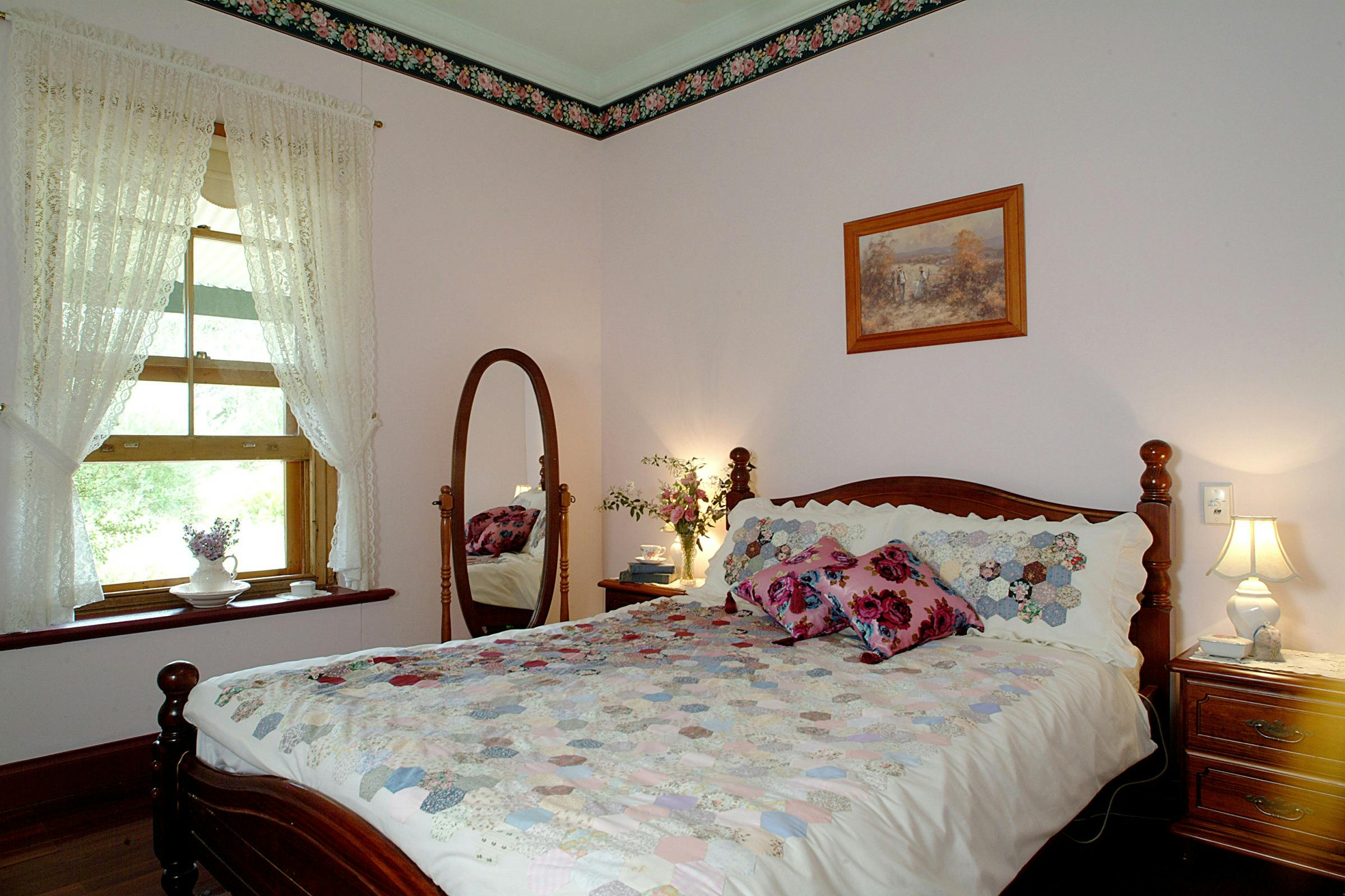 Queen size bed overlooks the cottage garden with is home to many native birds.