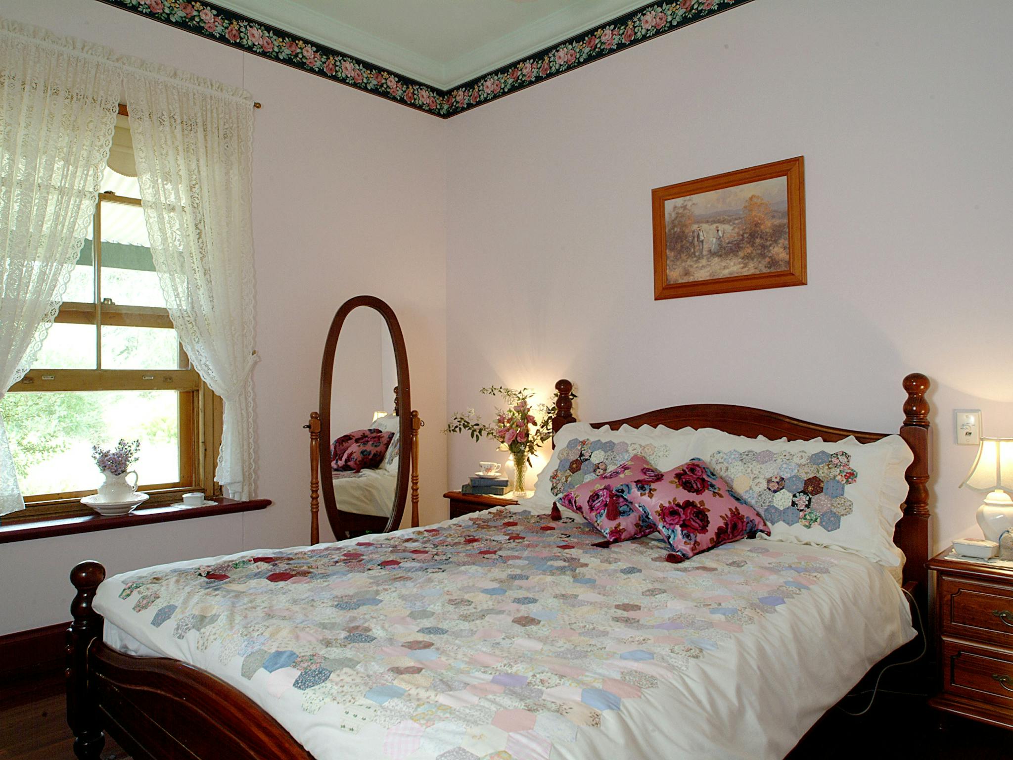 Queen size bed overlooks the cottage garden with is home to many native birds.