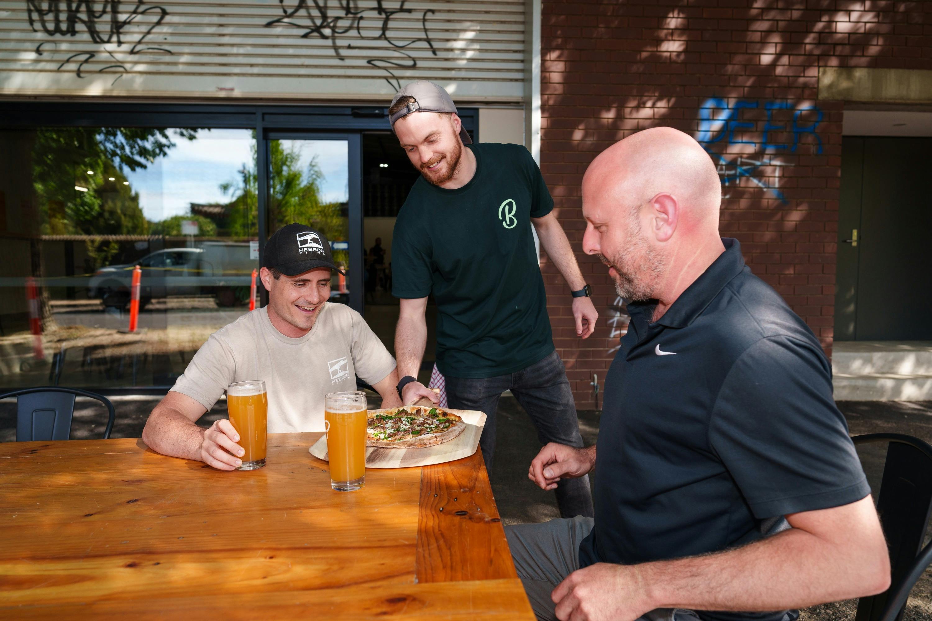 Patrons enjoying beer and pizza