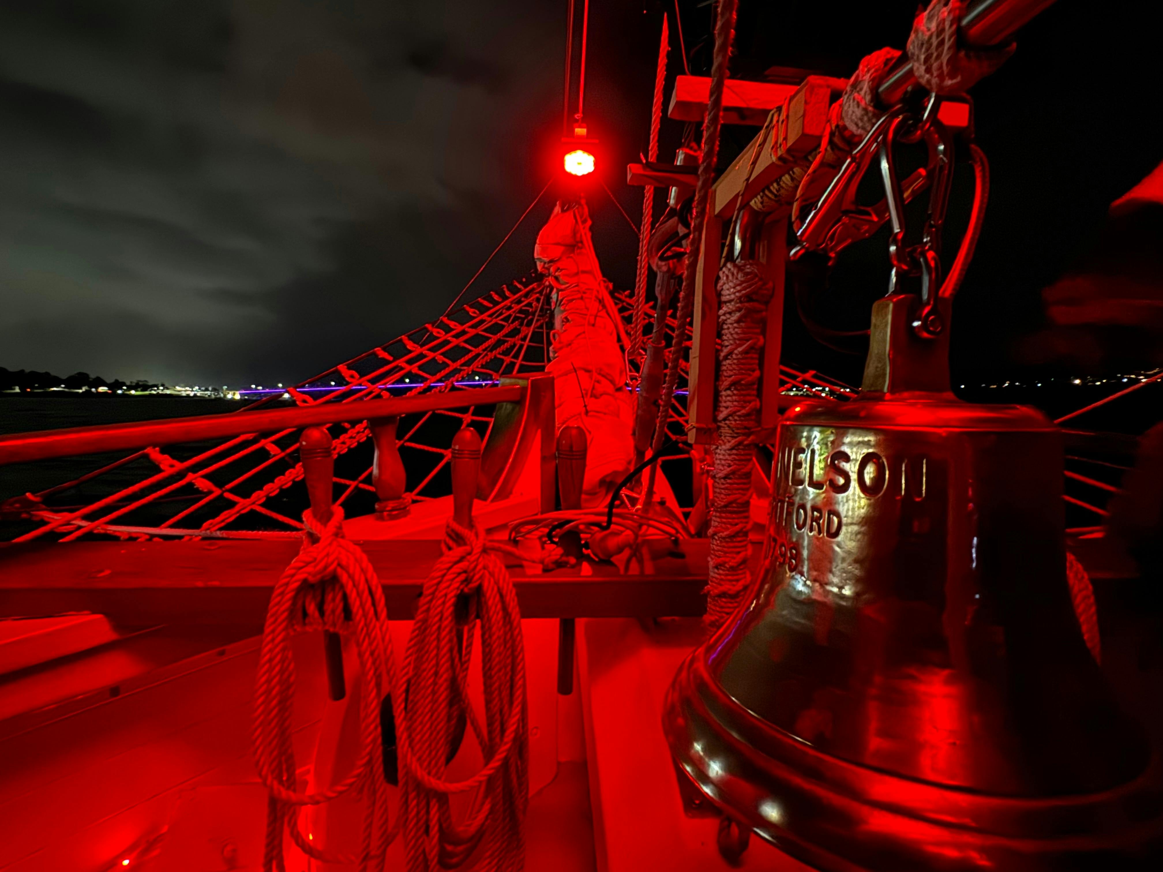 Bell and bowsprit glowing red in the darkness