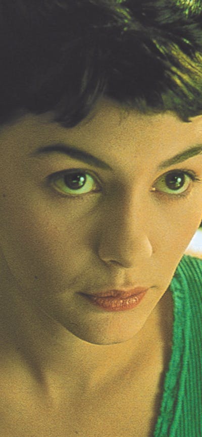 Woman with dark hair and green top looks up at the camera
