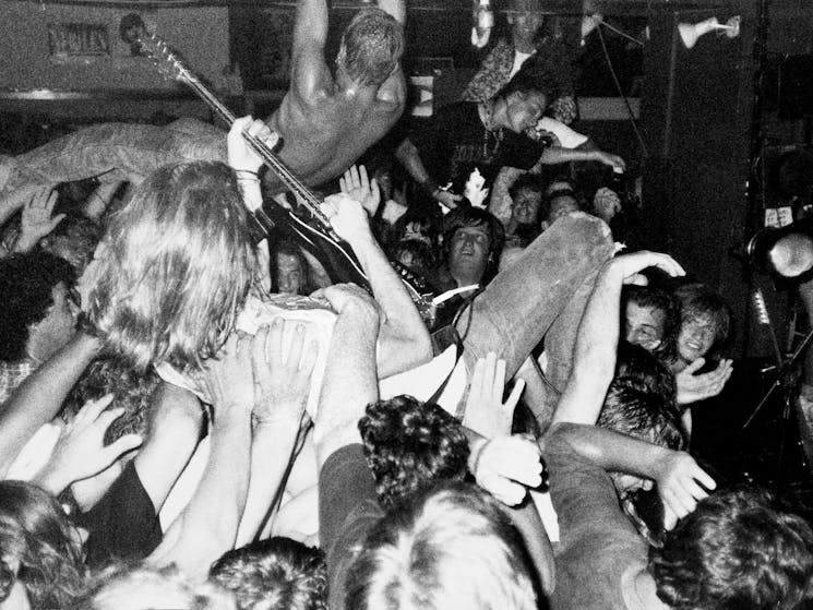 Black and white photo of Mudhoney band member in mosh pit in the Barwon Club Geelong 1990