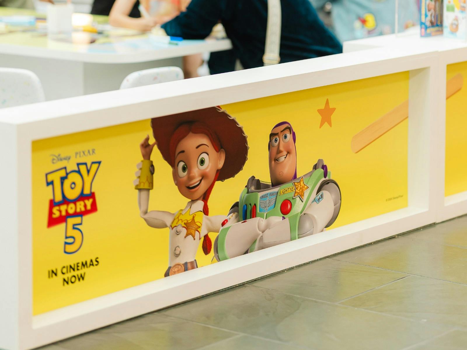 Base panel of the Toy Story  activity station, showing Jessie, Buzz and the TS5 logo