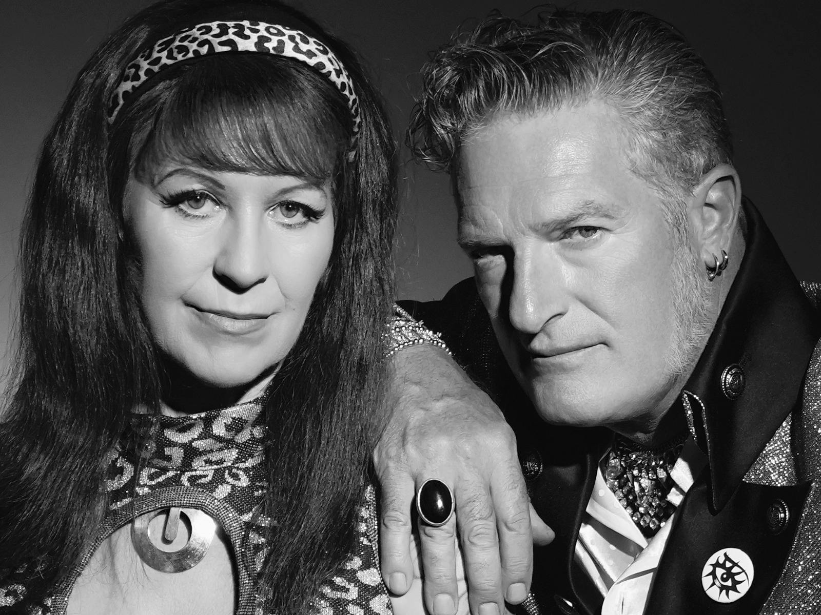 Black and white image of man and woman posing and looking at camera