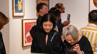 Two women observing objects relating to Cornel & Hiroe Swen's life at Canberra Museum + Gallery