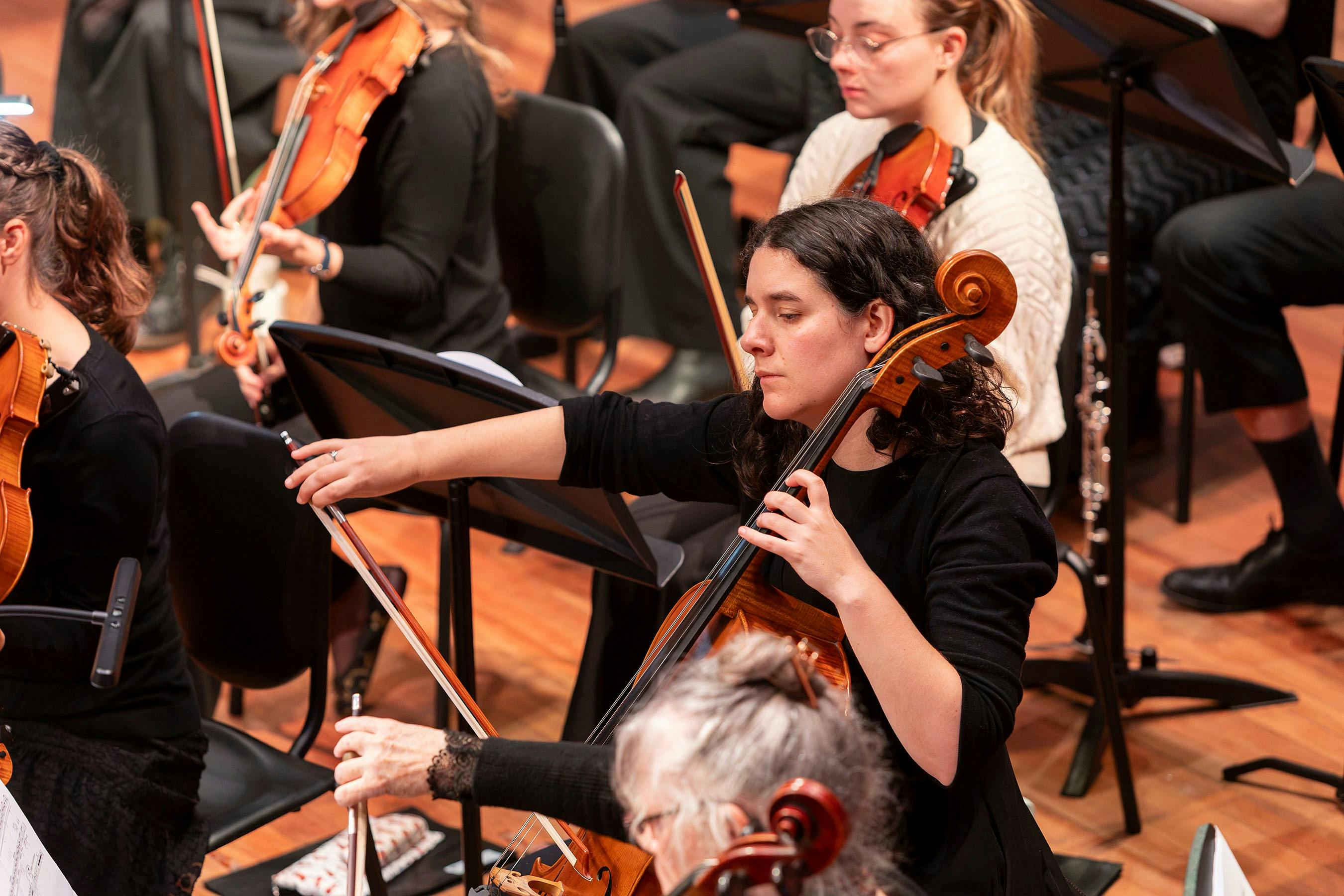 woman playing cello in orchestra