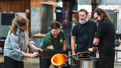 Artists blowing glass in the Hotshop at Canberra Glassworks