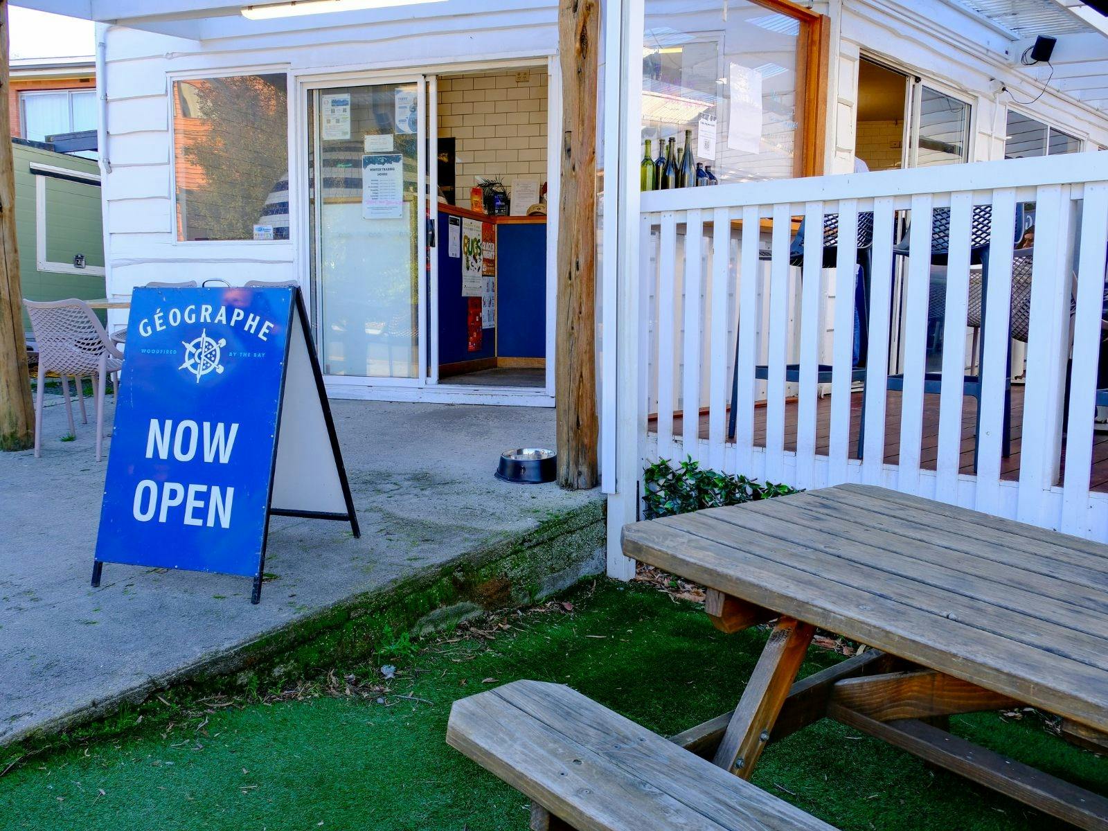 Entrance to Geographe Restaurant Espresso Bar with outdoor lawn seating in Coles Bay
