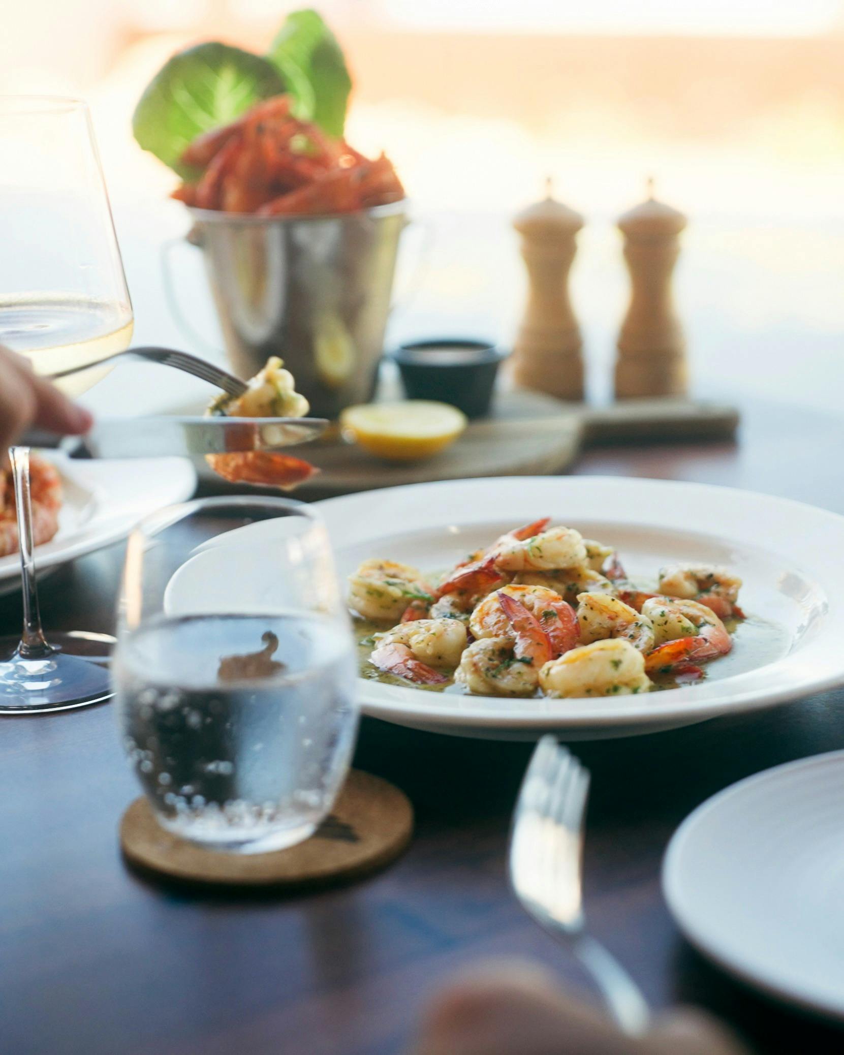 A plate of garlic prawns on a table and Mantarays Ningaloo Beach Resort