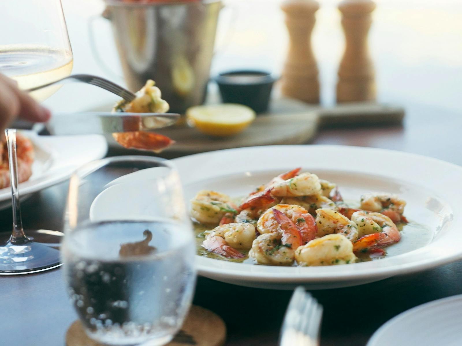 A plate of garlic prawns on a table and Mantarays Ningaloo Beach Resort