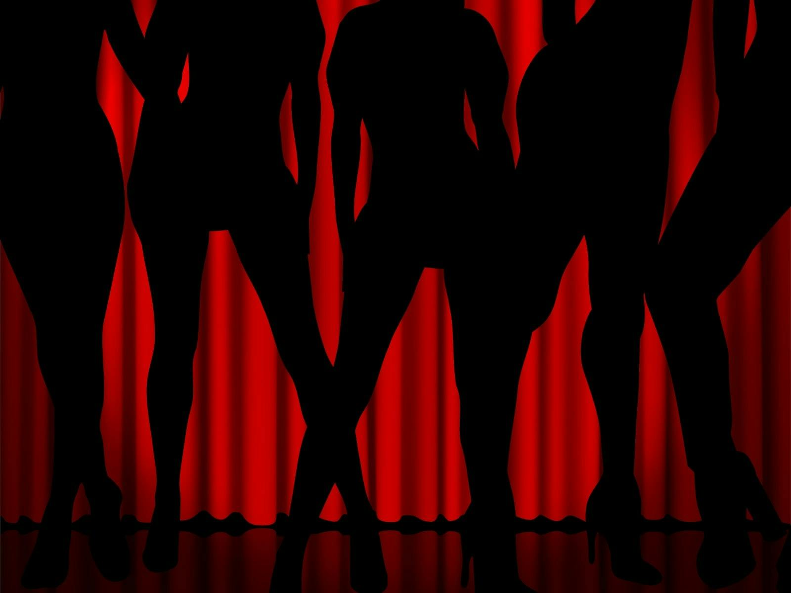 Black shadows of womens bodys against a red theatre curtain