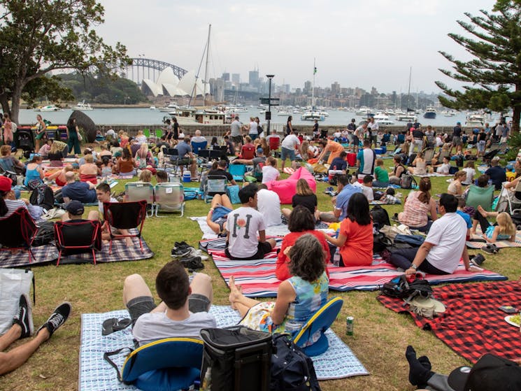 Guests sitting on their picnic blankets and overlooking the Sydney Harbour