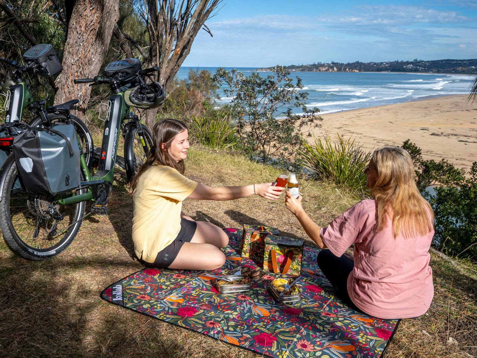 Two guests overlooking Tathra Beach on a pedal and picnic tour.