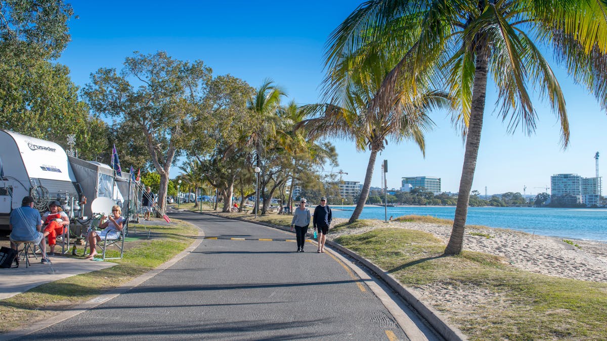 Image of waterfront caravan sites with people walking next to the beach Image of waterfront caravan sites with people walking next to the beach