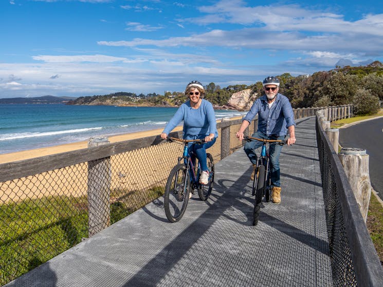 Two guests cycle next to Aslings Beach Eden