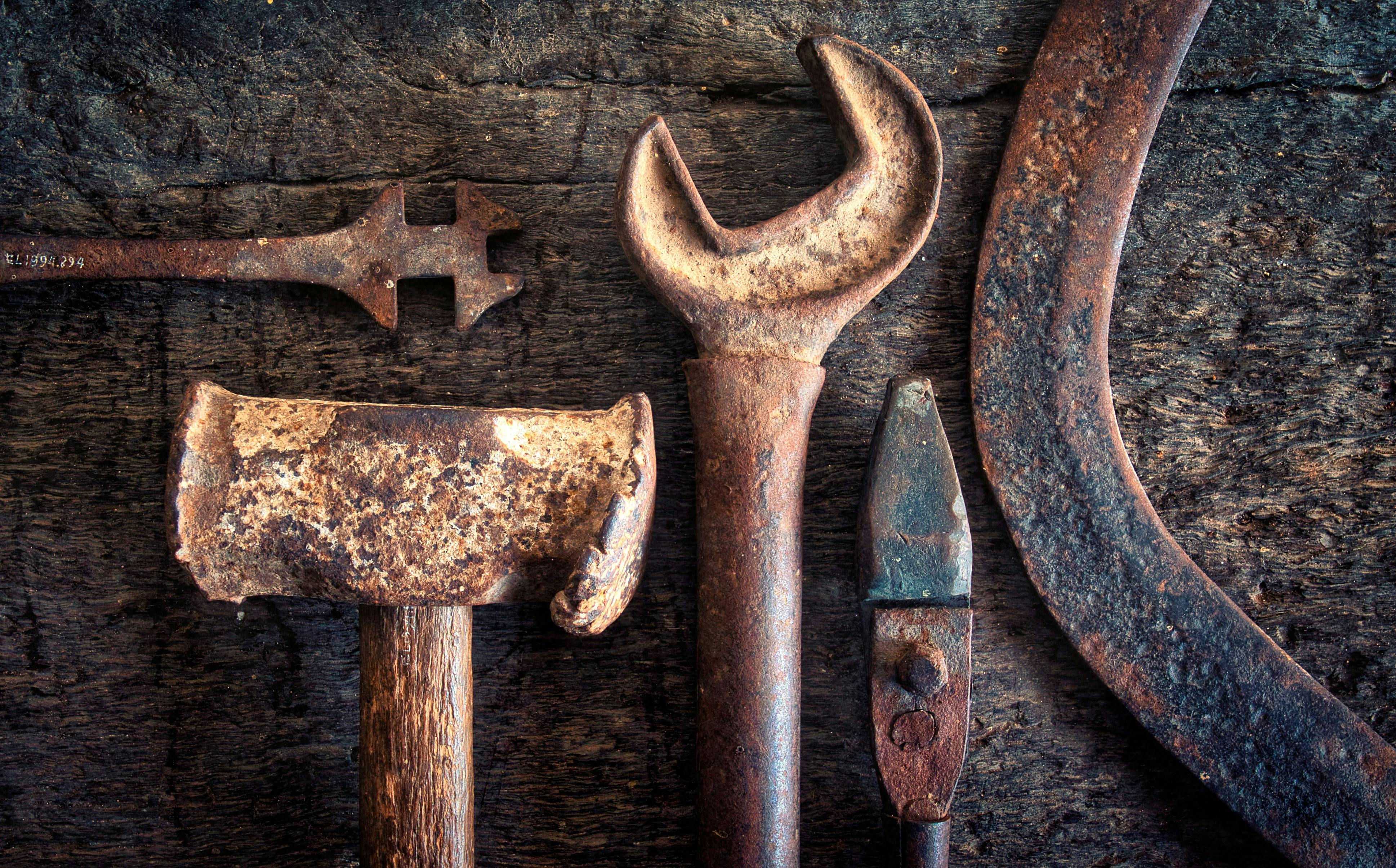 Tools laid out on a workbench - signs of wear on all tools and bench.