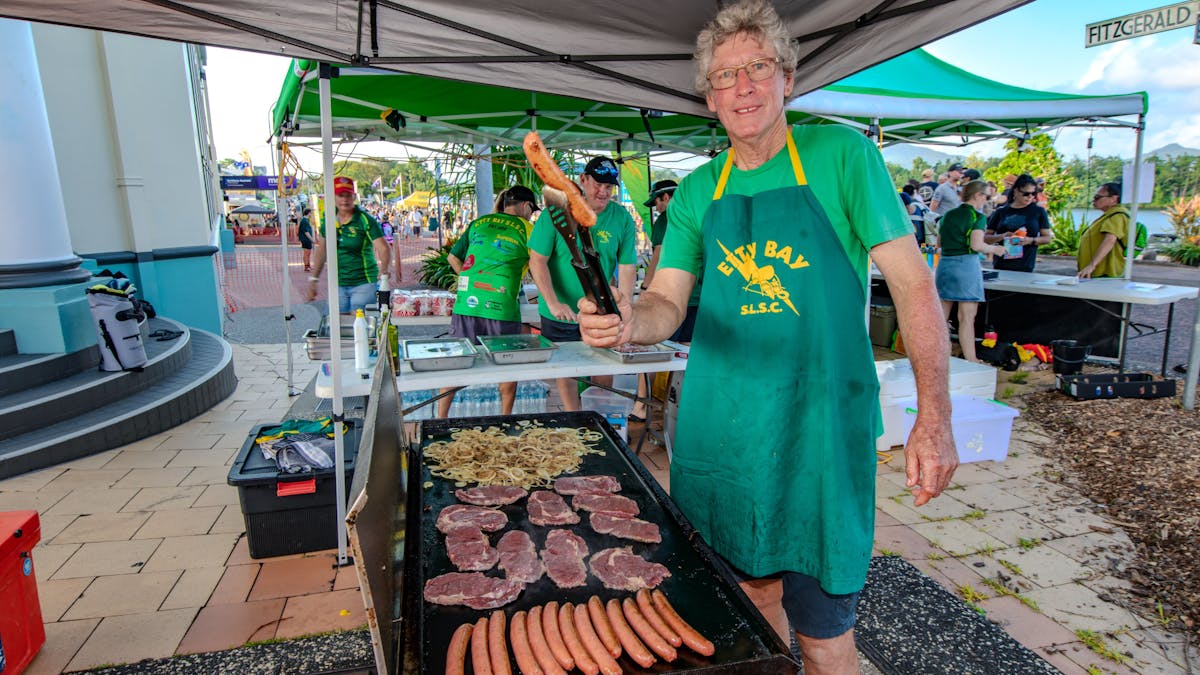 The volunteers from Etty Bay Surf Life Savers cook up a Aussie BBQ for the crowds