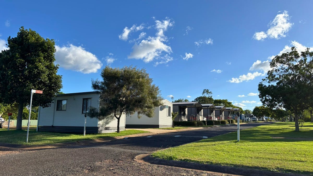 Row of modern cabins along a quiet internal road with manicured lawns