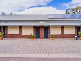 Exterior of the Pastoral Hotel Motel accommodation units with brick facade, solar panels, and plants