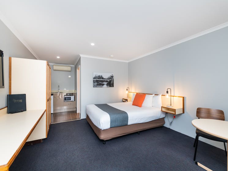 Living area and bedding of River Motel's Queen Room