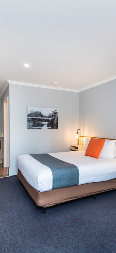 Living area and bedding of River Motel's Queen Room