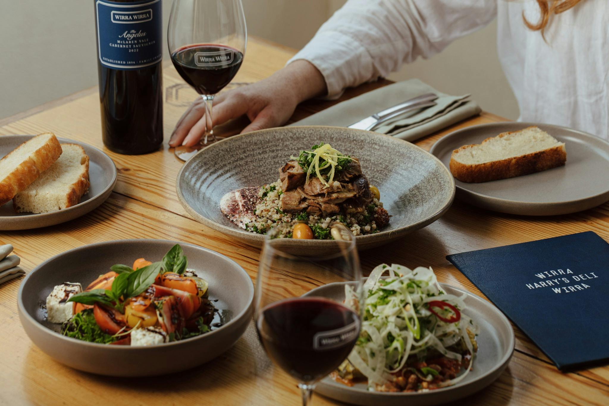 A table with shared plates and glasses of Wirra Wirra wine