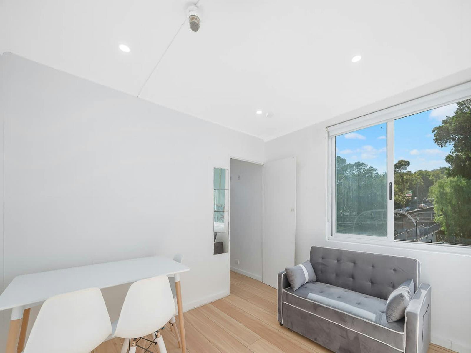 Open-plan living space with a dining table and a comfortable sofa that converts into a sofa bed