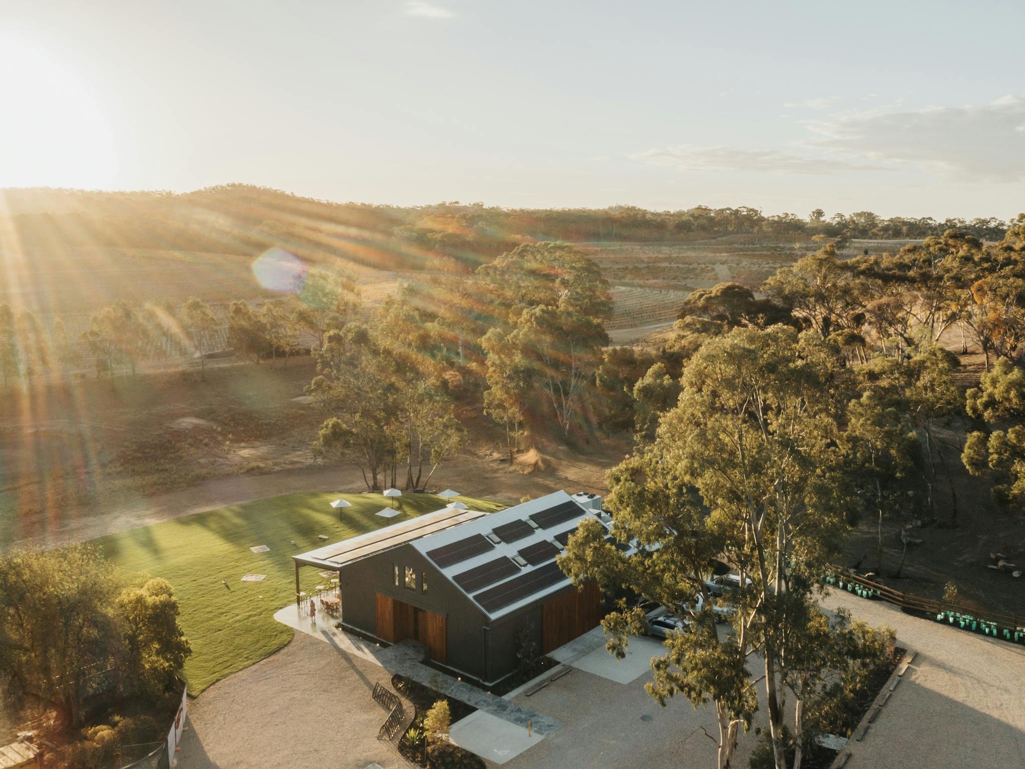 Skillogalee Estate Barrel House Drone Shot overlooking the shed, lawn and vineyard with trees around