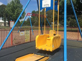 A bright yellow coloured held by blue struts. The  swing is suitable for wheelchair access.
