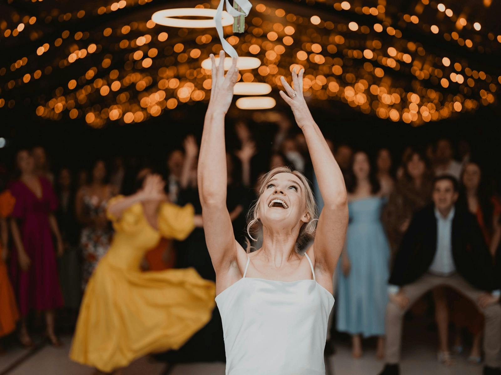 throwing flowers under fairy lights