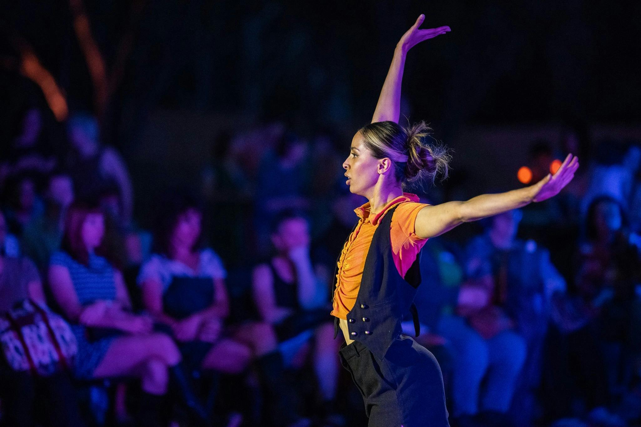 A dancer with arms raised performs at the Desert Festival for larger audience