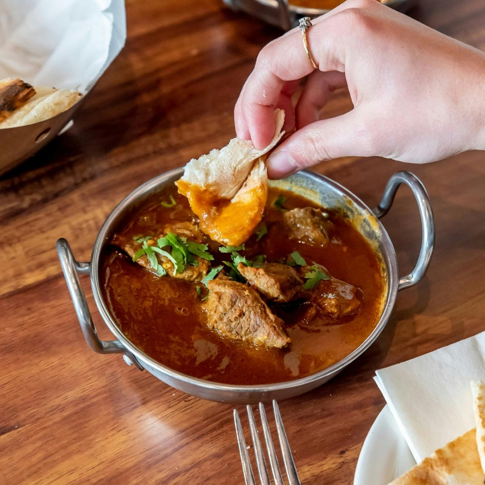 Scooping up curry with naan