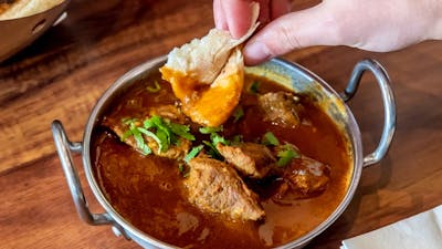 Scooping up curry with naan