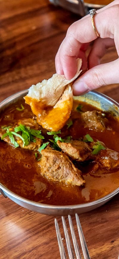 Scooping up curry with naan