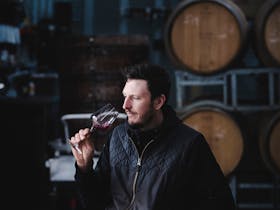 Winemaker smells wine in barrel room