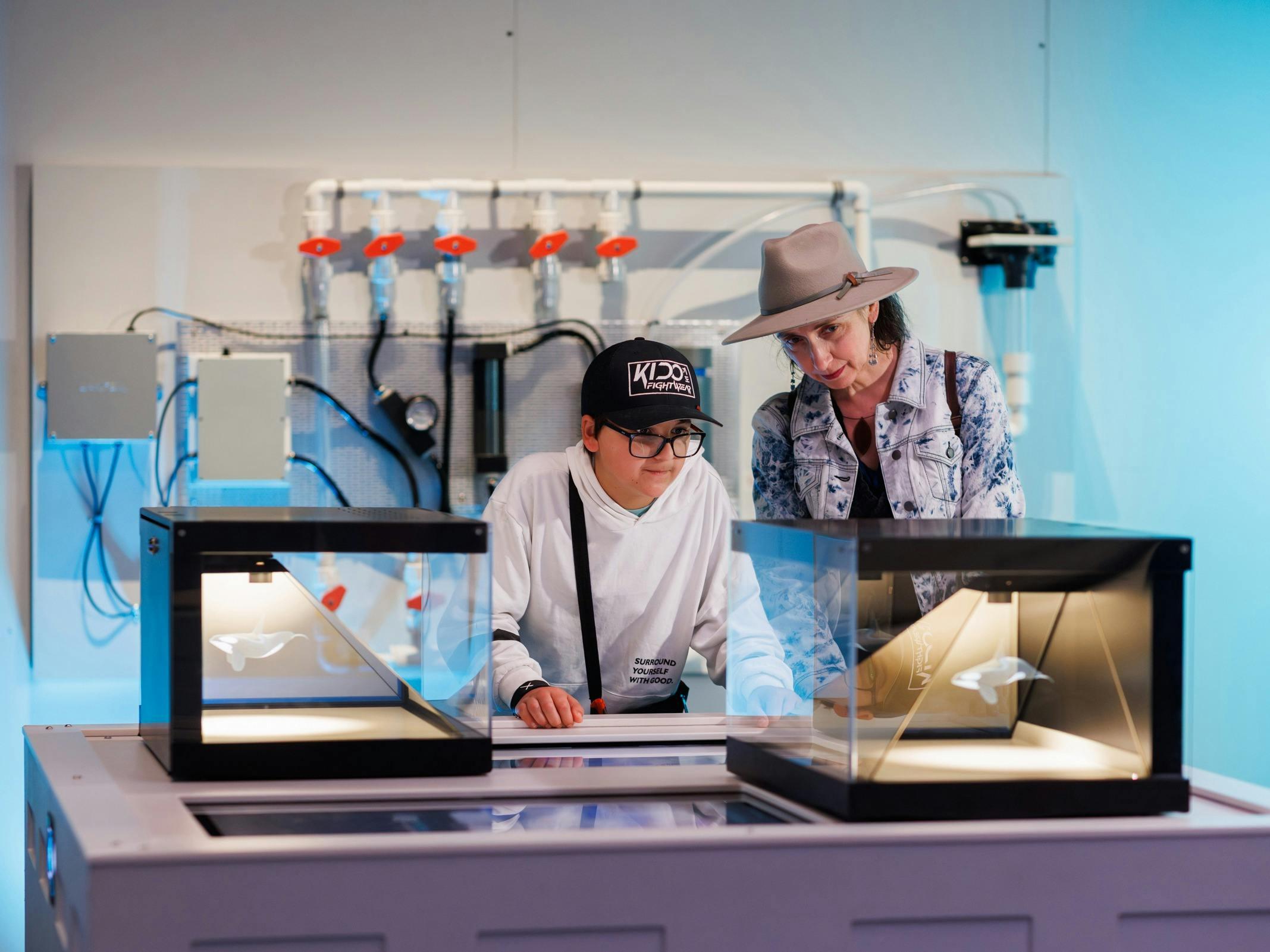A woman and a young boy look at displays in a replica laboratory