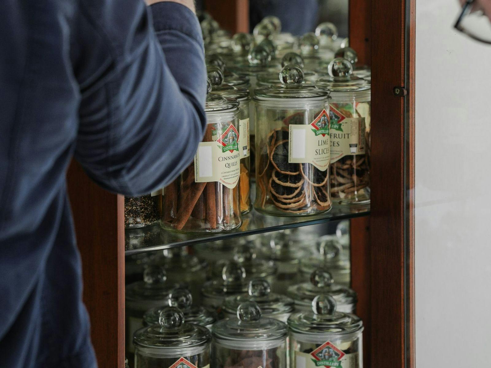 Participant selecting flavour profiles from jars during the liqueur making class.