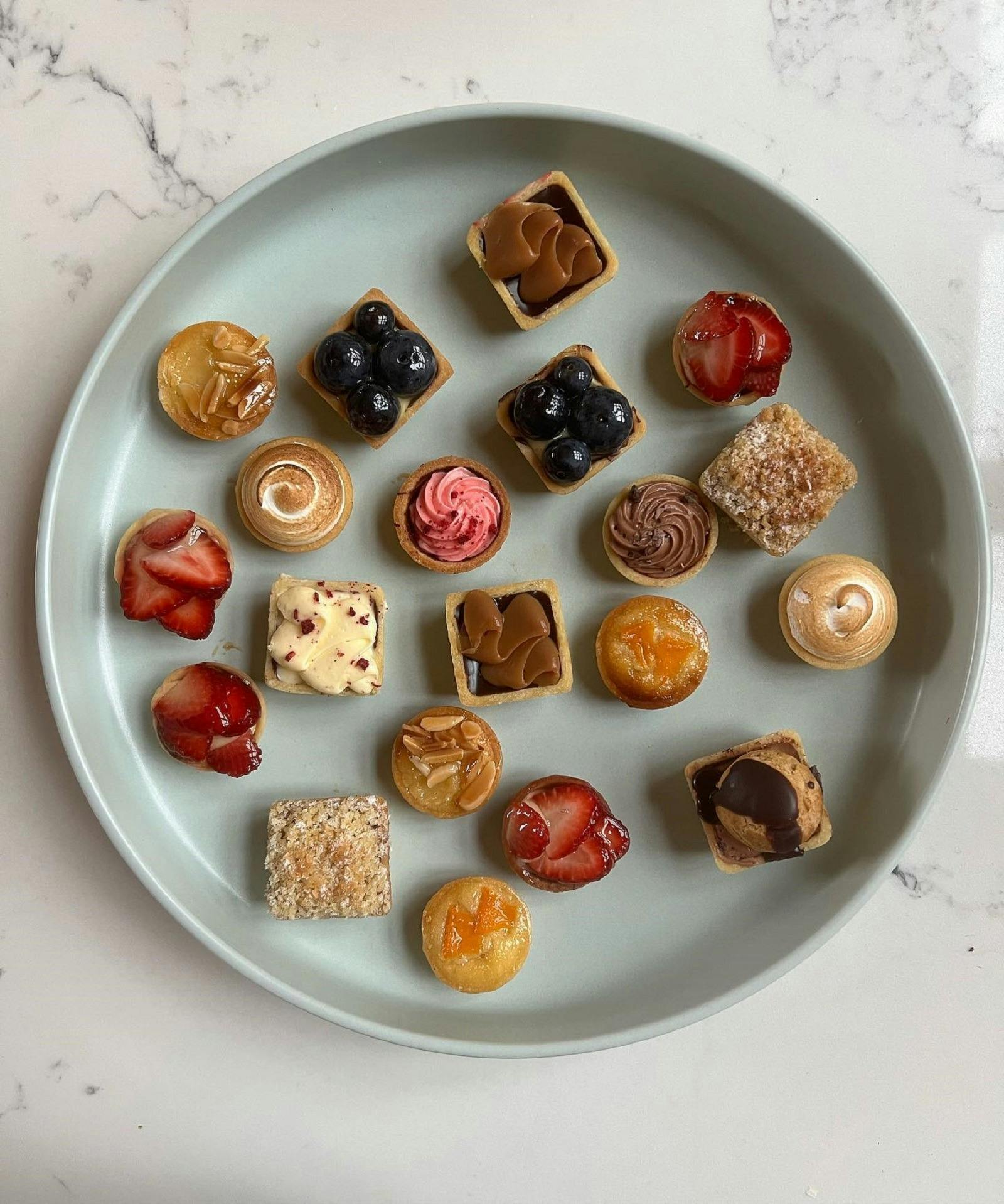 A collection of mini tarts on a plate.