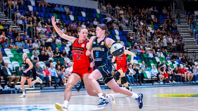 UC Capitals player driving to the basket for a layup during a WNBL game against Perth Lynx.