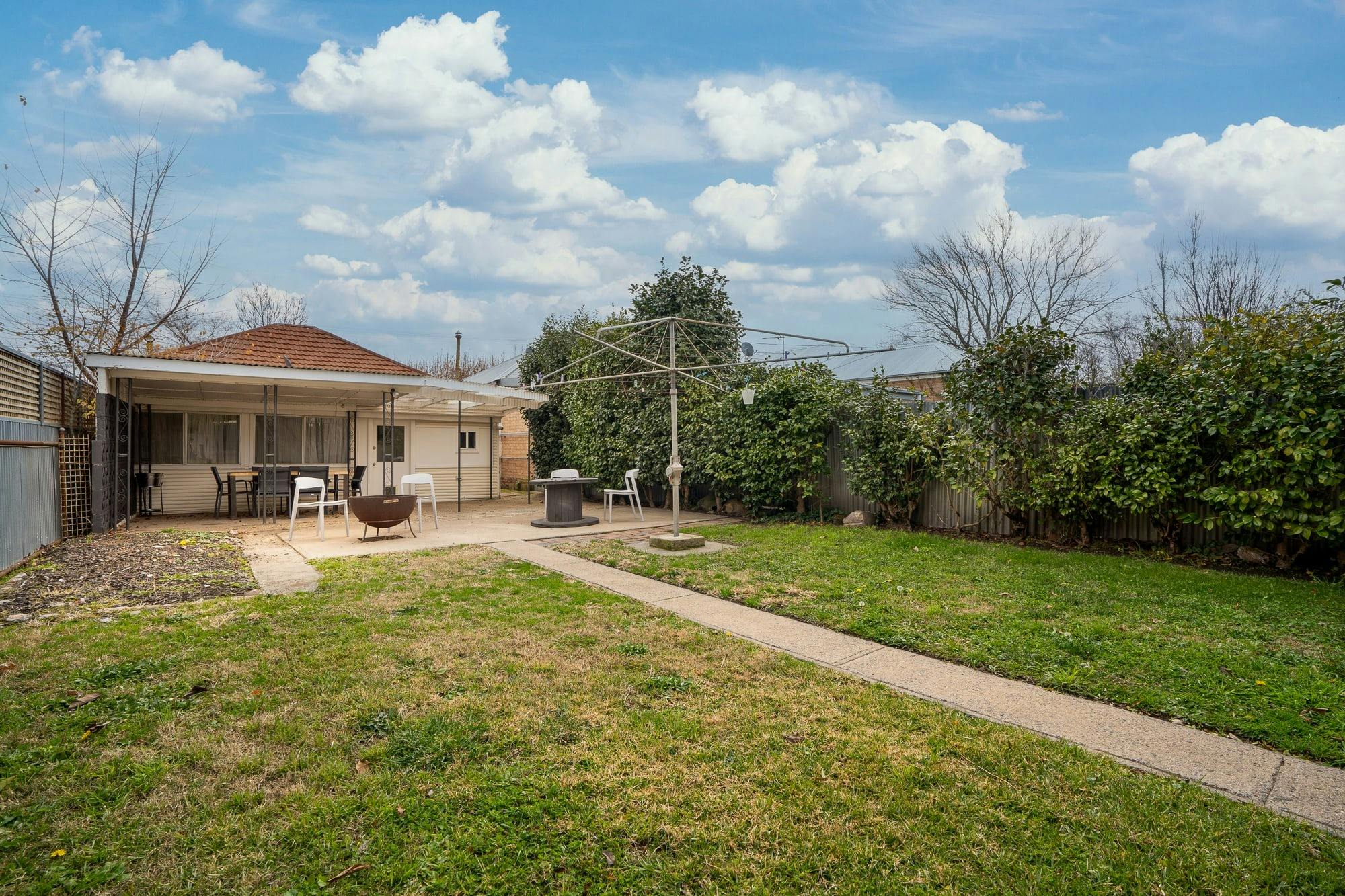 Large backyard with grass and cemented area