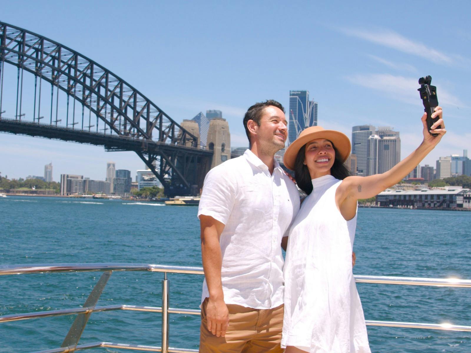 couple enjoying sightseeing cruise in front of Sydney Harbour Bridge