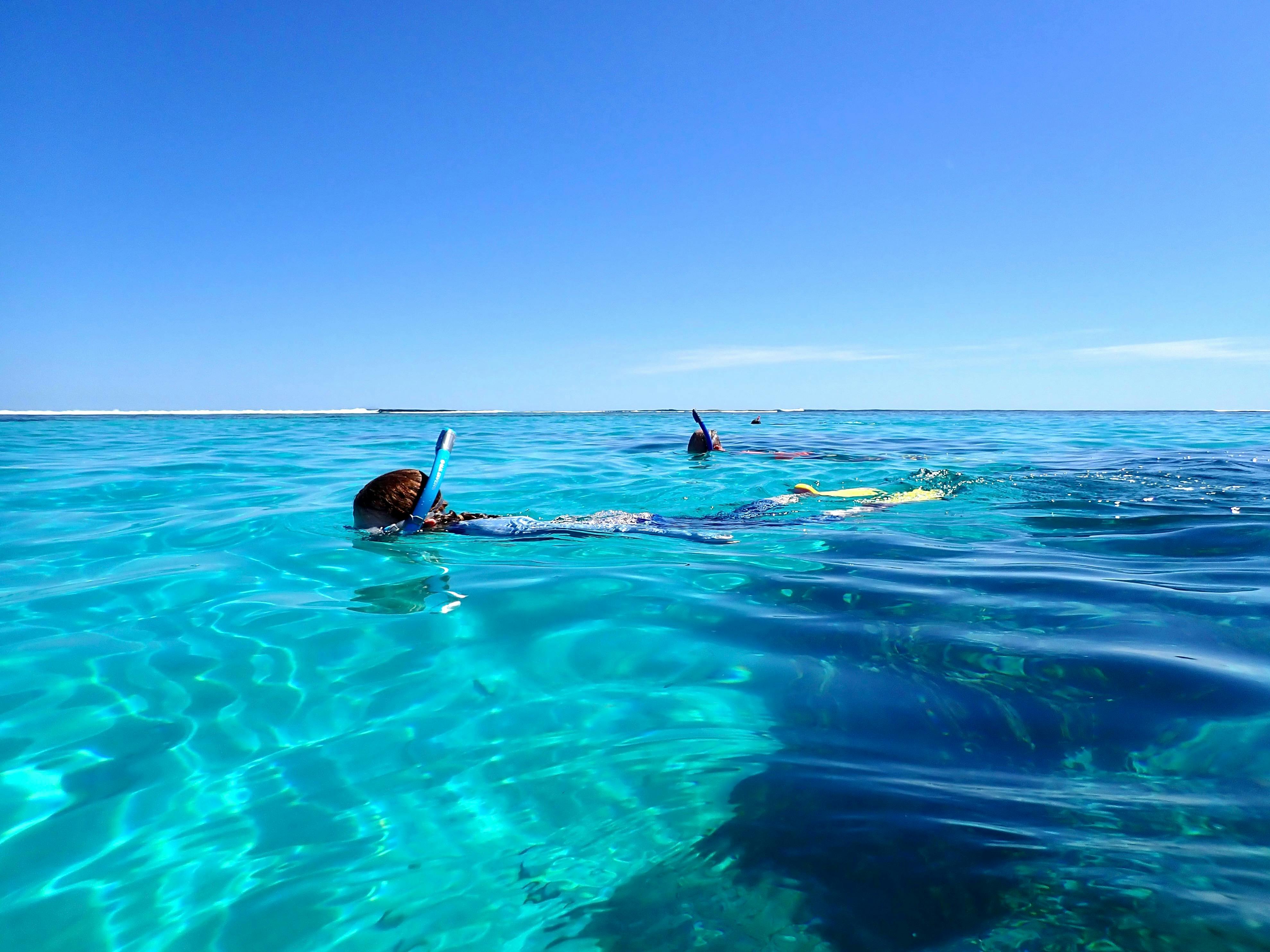 Two snorkellers in glassy turquoise water