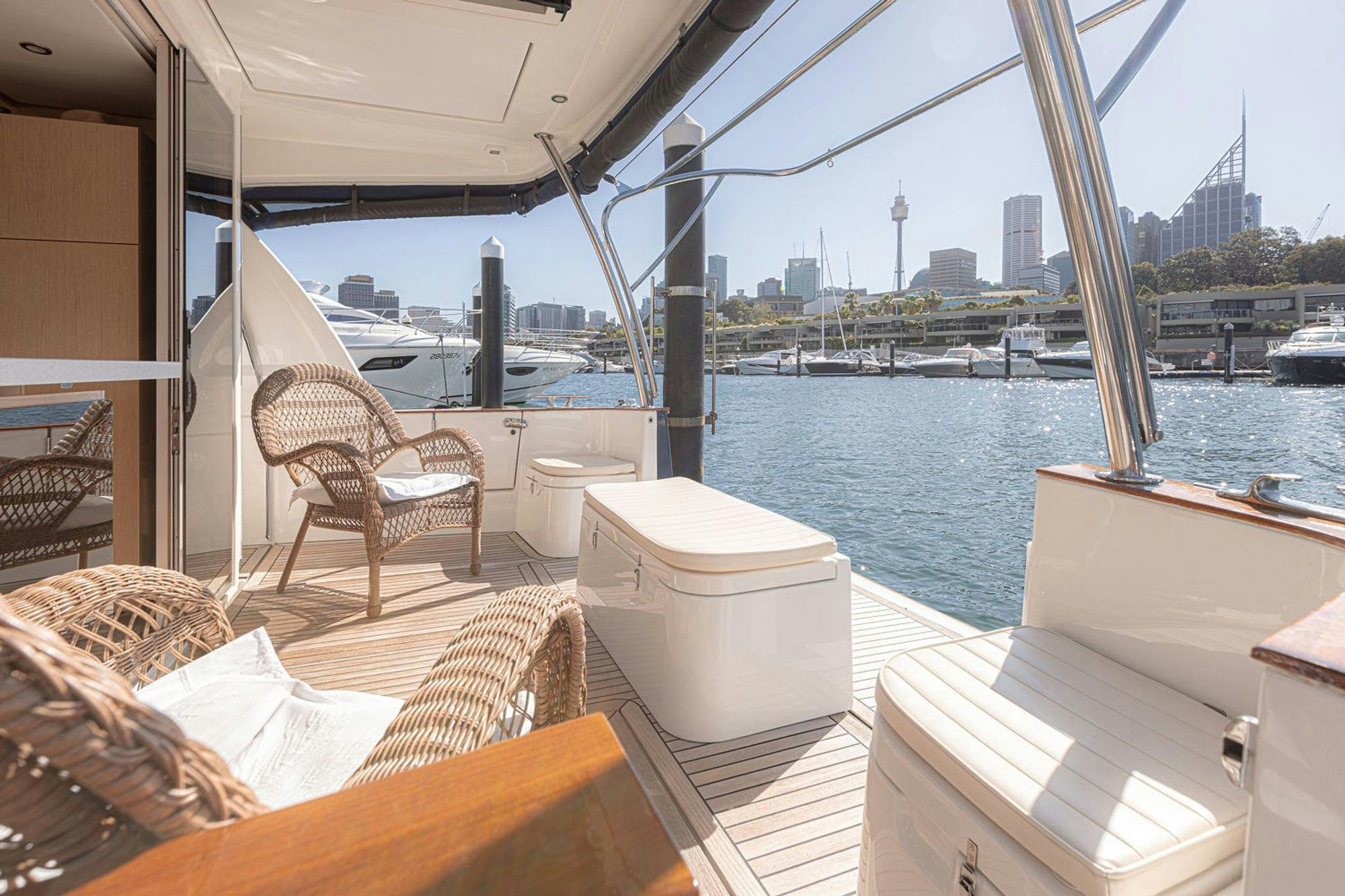 EV Arcadia aft deck with wicker chairs and Sydney CBD skyline from Woolloomooloo
