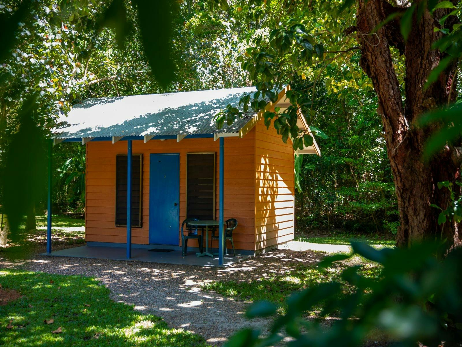 Standalone cottage surrounded by gardens and trees with a front veranda Standalone cottage surrounded by gardens and trees with a front veranda