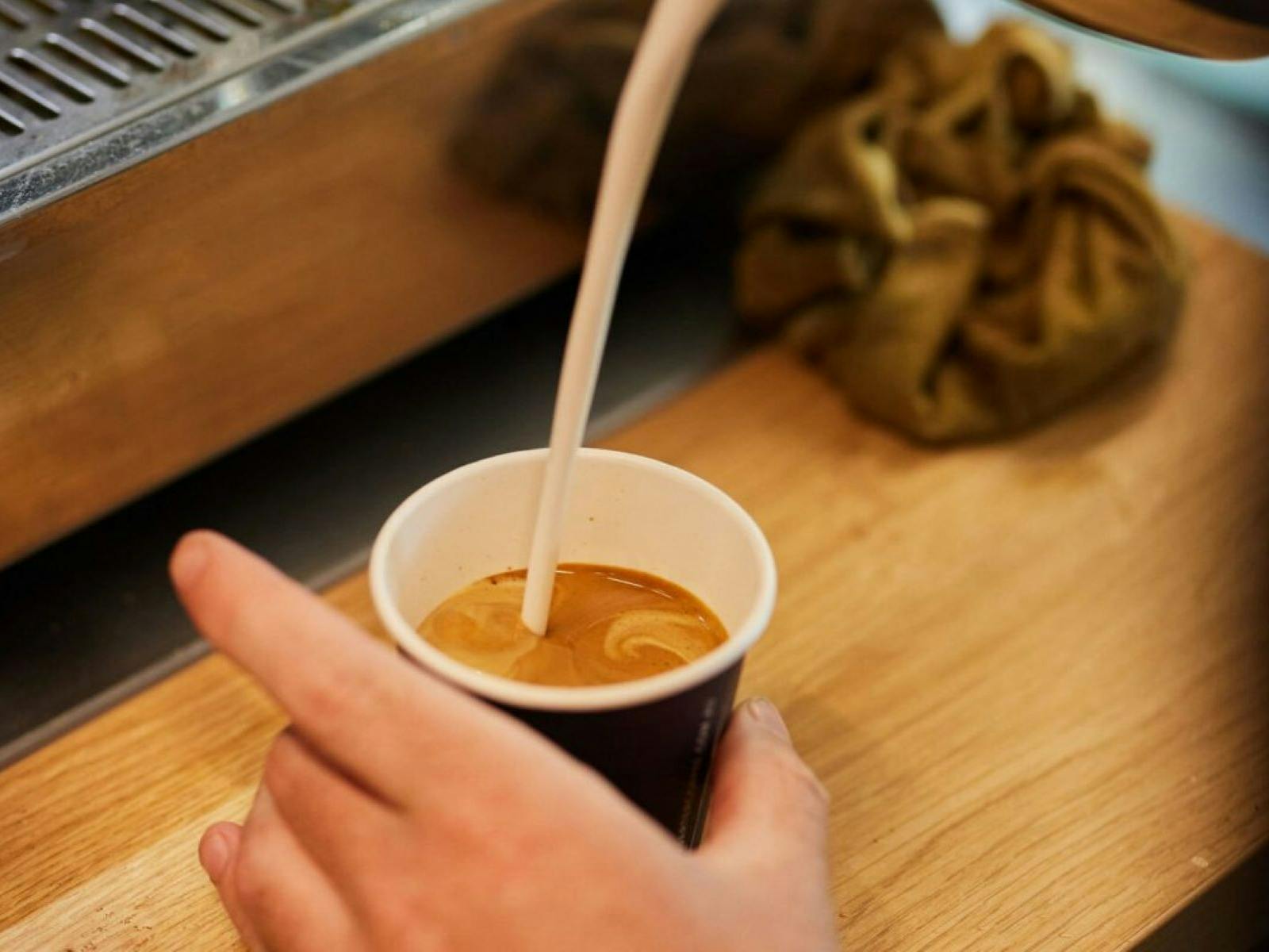 milk being poured in coffee