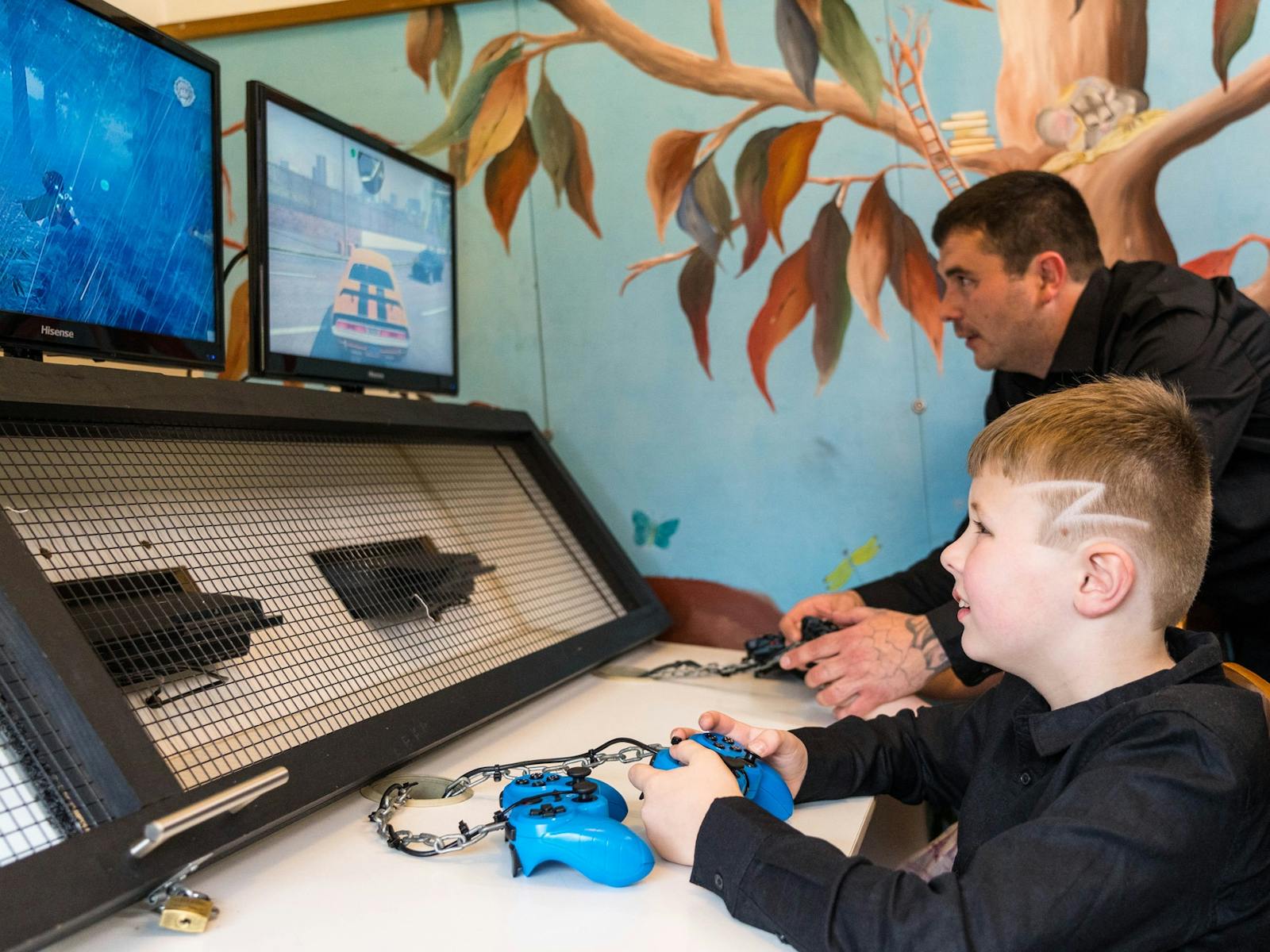 A father and children play on our PlayStation consoles in the Kauri Bistro's playroom