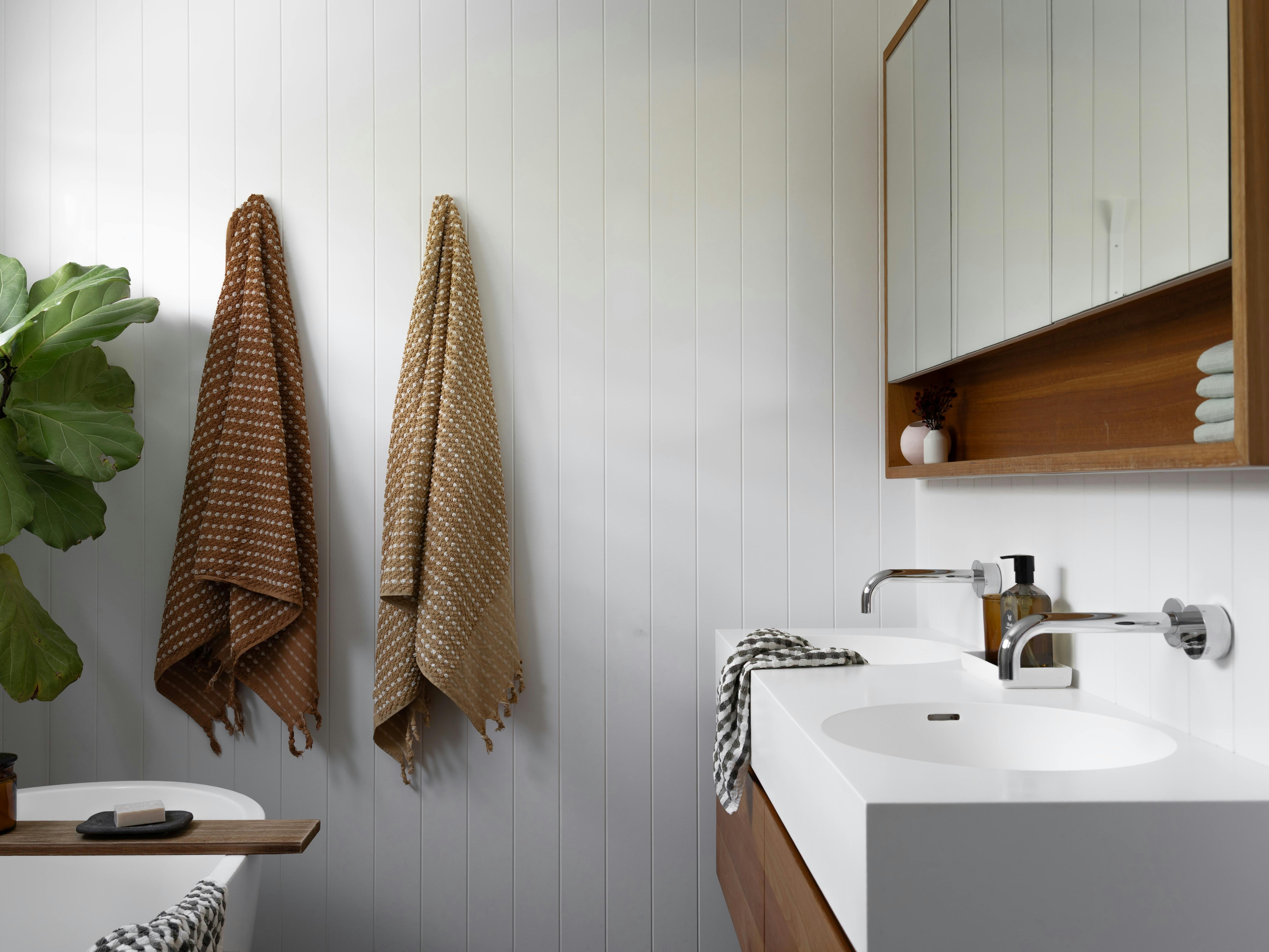 Coastal white bathroom with coloured towels hanging