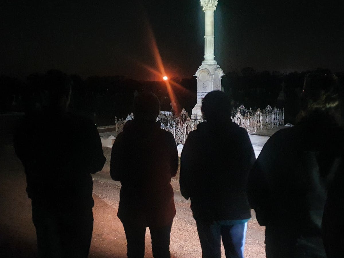 silhouette of group of 4 people standing in front of graveyard statue silhouette of group of 4 people standing in front of graveyard statue