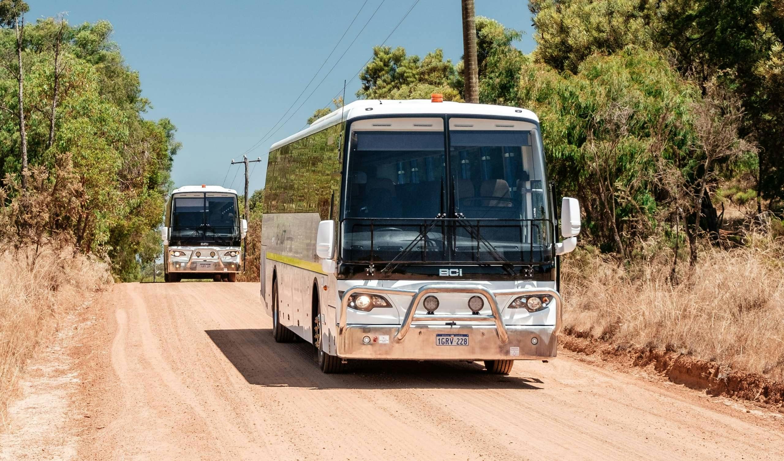 Picture of a bus driving down a  dirt road